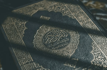 Quran, close up picture of blue leather binding adorned with gold imagery. 
