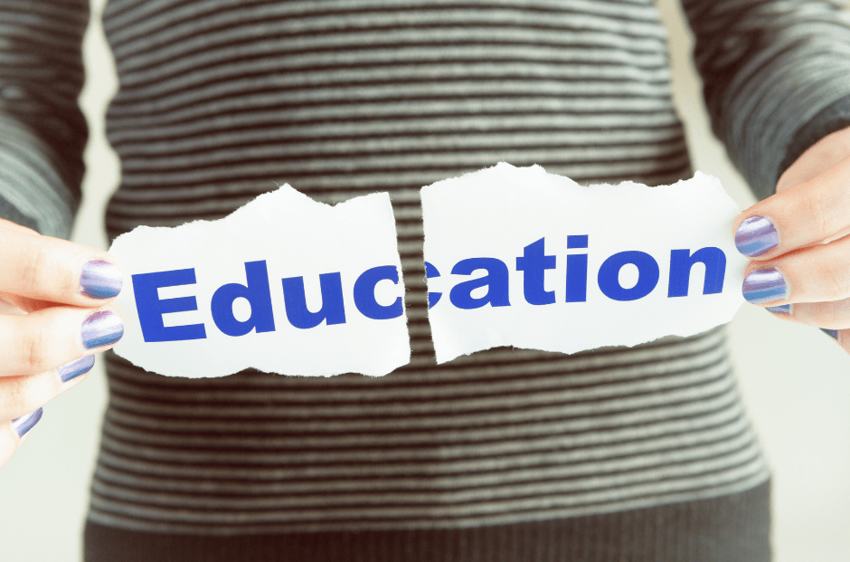 A person holding a piece of paper that has the word "Education" on it, torn down the middle.